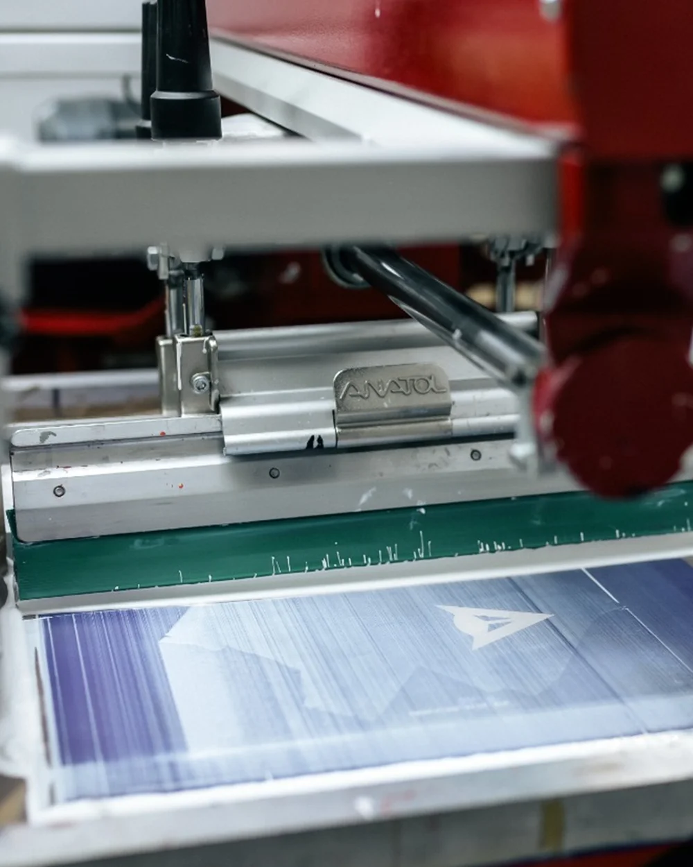 Cap de raclă Anatol pe mașina de serigrafie în timpul transferului de cerneală pe material imprimat cu logo - Antel Print