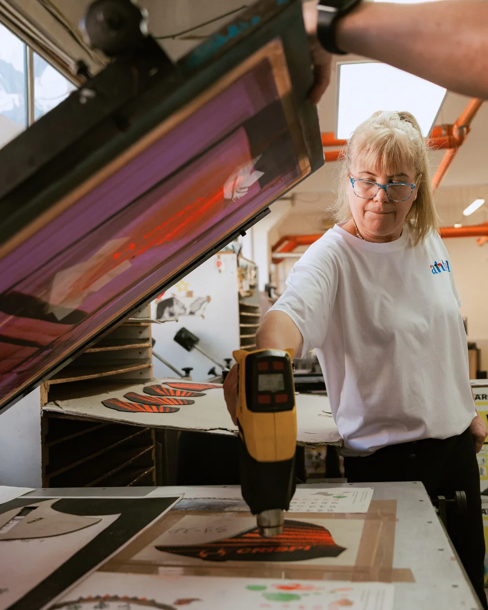 Operator Antel Print uscând cu aer cald piesele serigrafiate - Antel Print