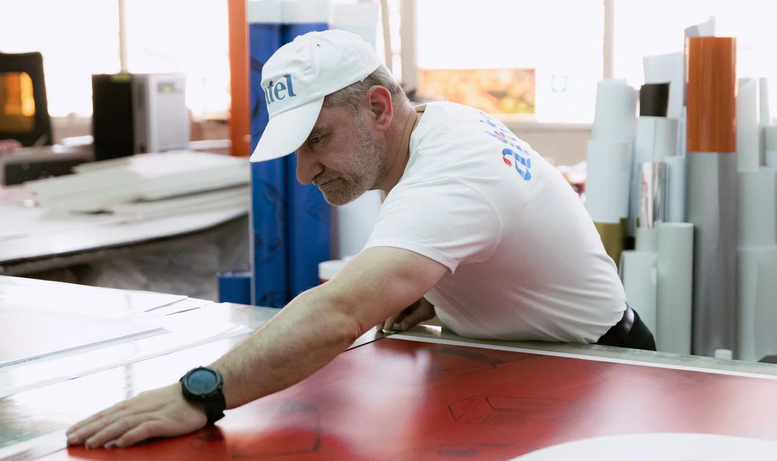 Operator Antel Print verificând manual banner tipărit roșu