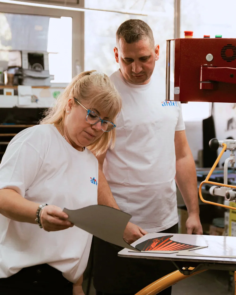 Operatori Antel Print verificând calitatea piesei serigrafiate - Antel Print